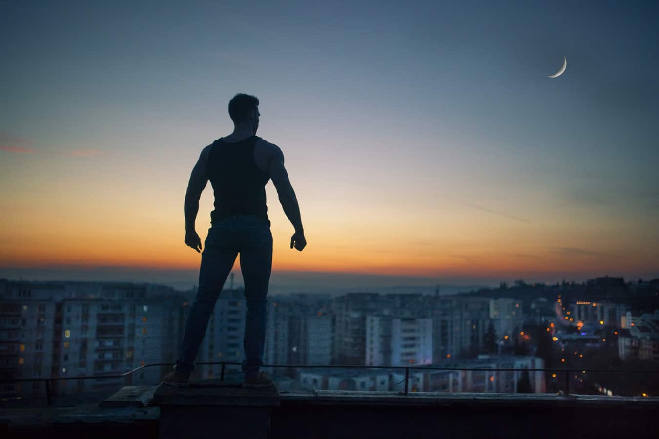 man standing on top of a building at sunrise